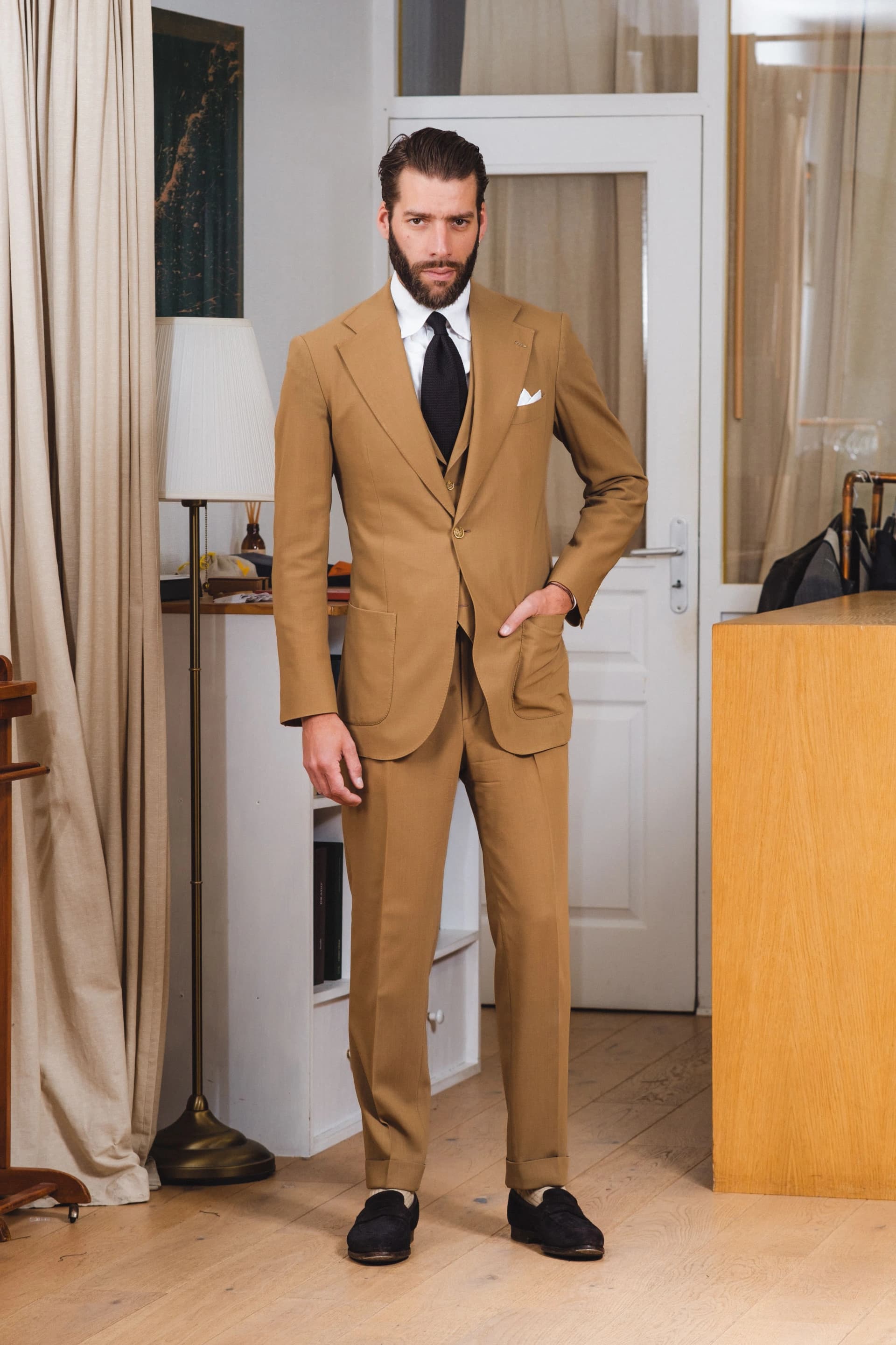 Costume trois pièces beige avec chemise blanche et cravate noire
